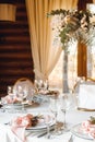 Wedding table setting with empty wine glasses and fresh flowers