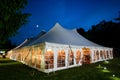 A wedding tent at night with blue sky and the moon. The walls are down and the tent is set up on a lawn - wedding tent series