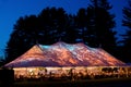 Wedding tent at night - Special event tent lit up from the inside with dark blue night time sky and trees Royalty Free Stock Photo