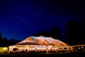 Wedding tent at night - Special event tent lit up from the inside with dark blue night time sky and trees Royalty Free Stock Photo