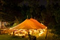 A wedding tent at night surrounded by trees with an orange glow from the lights, long exposure - wedding tent series Royalty Free Stock Photo