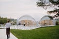 Long white tent for wedding party in the woods.