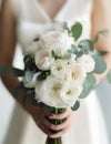 Wedding Theme, Bride holding beautiful wedding posy with white roses and green foliage, stems covered with white ribbon