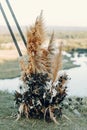 Wedding triangular arch in boho style. Floristics from dried flowers for a wedding, exit ceremony.