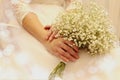 A wedding is a troublesome business: a delicate bouquet in the hands of the bride lies on a wedding dress, close-up, space for