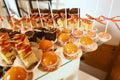 Wedding variety dessert cakes with tasty buffet color decorated with whipped orange cream, candy bar, buffet