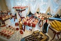 Wedding variety dessert cakes with tasty buffet color decorated with whipped red pearl cream, candy bar, buffet on a glass tray