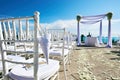 Wedding venue setting on the hill, arch and altar decoration, white chairs with cone of rose of petals Royalty Free Stock Photo