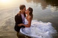 Wedding, water and wet bride with groom hug, kiss and standing in lake together with passion, smile and romance. Love Royalty Free Stock Photo