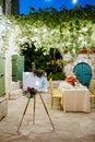 Wedding welcome sign on a tripod decorated with flowers near the set festive table Royalty Free Stock Photo