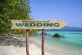 Wedding wooden arrow road sign against tropical beach with white sand and turquoise water background Royalty Free Stock Photo