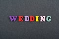 WEDDING word on black board background composed from colorful abc alphabet block wooden letters, copy space for ad text. Learning