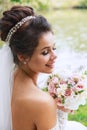 Wedding day. Young beautiful bride with hairstyle and makeup posing in white dress and veil. Royalty Free Stock Photo