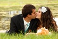 Wedding, young bride and groom in love lying on green grass, par