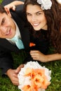 Wedding, young bride and groom in love lying on green grass