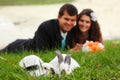 Wedding, young bride kiss groom in love lying on green grass wit