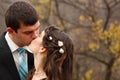Wedding, young groom kiss bride in love over autumn nature backg