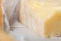 Wedge of aged cheese in white paper