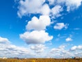 Wedge of clouds in blue sky over yellow city park Royalty Free Stock Photo