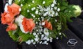 Weeding rings on top of white, green and pink roses bouquet.