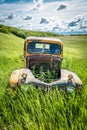 Weeds growing up through the empty hood of an abandoned antique truck near Wymark, SK Royalty Free Stock Photo