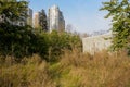 Weedy trail before modern dwelling buildings in sunny winter afternoon