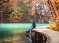 Weekend in autumn park 0 father with son sit on bridge near the