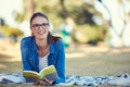 The weekend doesnt get better than this. an attractive young woman reading a book while relaxing in the park. Royalty Free Stock Photo