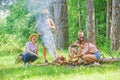 Weekend in forest benefits. Roasting marshmallows popular group activity around bonfire. Company friends prepare roasted Royalty Free Stock Photo