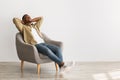 Happy African American Man Relaxing Sitting In Chair, Gray Background Royalty Free Stock Photo