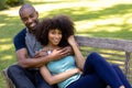 Happy young couple sitting on a bench in the garden Royalty Free Stock Photo