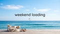Weekend Loading Text on Tropical Beach with Ocean View and Beach Accessories Royalty Free Stock Photo