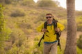 Weekend outdoors - young happy and attractive hiker man with backpack walking around in the wood enjoying hiking activity and Royalty Free Stock Photo