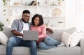 Weekend Passtime. Married Afro Couple Using Laptop At Home Together, Watching Movies