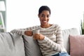 Weekend Pastime. Happy Black Lady With Cup Of Coffee Relaxing On Couch