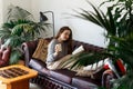 Weekend Pastime. Young Woman Relaxing In Armchair With Book And Coffee Enjoying Spending Time At Home home trees around.