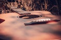 The guitar lies on the ground among the autumn grass and is freshened by the sun. Eye level shooting. Soft focus. Royalty Free Stock Photo