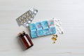 Weekly pill box and bottle with medicaments on white wooden table, flat lay Royalty Free Stock Photo