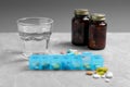 Weekly pill box with medicaments and glass of water on grey marble table Royalty Free Stock Photo