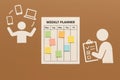 A weekly planner with colorful sticky notes. One person is juggling devices, while another is checking a list. The background is a Royalty Free Stock Photo