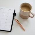 A weekly planner rests open on a white surface, displaying a grid of dates. Next to it, a Royalty Free Stock Photo