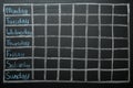 Weekly school timetable drawn on black chalkboard