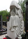 Weeping woman. Sculpture in the cemetery. The figure of a mother, wife or woman in a hood or stole. Lamentation for the
