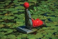 Seal statue with ball in the nose on the canal water with aquatic plants at Weesp.