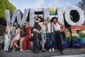 WeHo Pride participants pose in front of the WeHo Pride sign