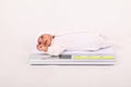 Weighing newborn baby boy on scale