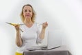 Weight loss fail concept. Scale and depressed, frustrated and sad woman sitting on floor holding head and arms on knees. Royalty Free Stock Photo