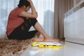 Weight loss fail concept. Scale and measure tape with depressed, frustrated and sad woman sitting on floor Royalty Free Stock Photo