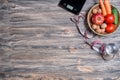 Weight loss and healthy eating concept. Plate with raw vegetables in it, kitchen scales, measuring tape and glass of water