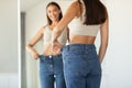 Lady Wearing Oversized Jeans Comparing Size After Slimming At Home Royalty Free Stock Photo
